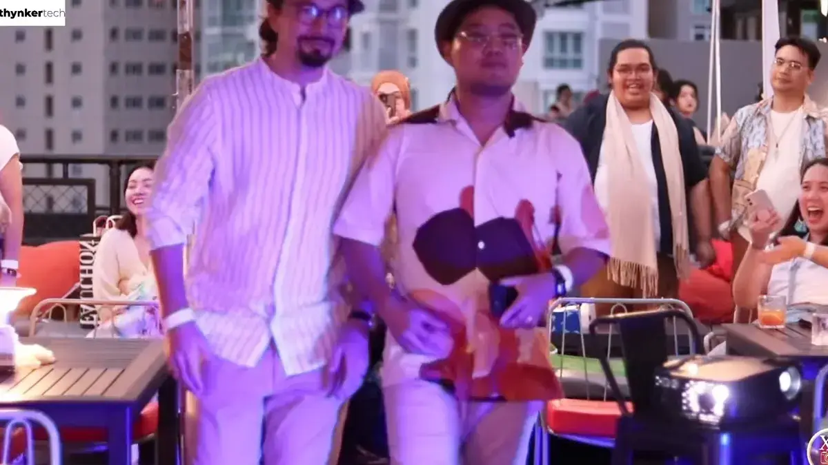 Performers in white entertaining guests at an evening rooftop party
