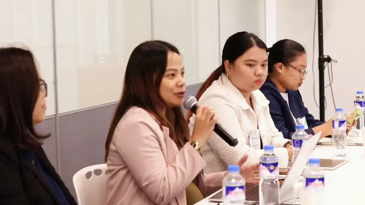 Panellists seated at a table answering questions at a conference