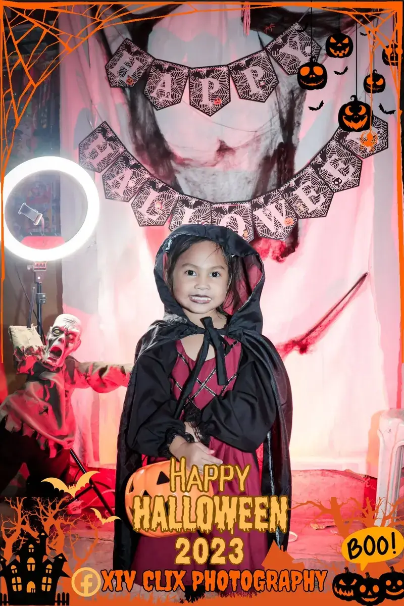 Young girl in a black witch costume at a Halloween photo booth