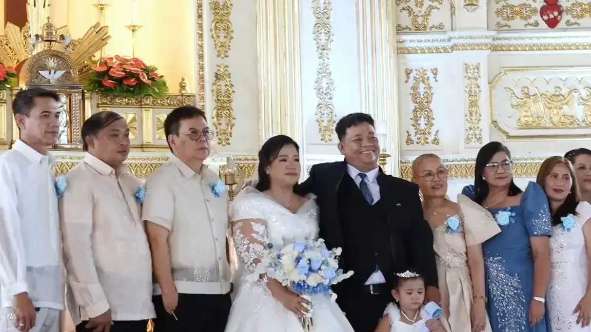 Newlyweds with their families and wedding party in front of the church altar